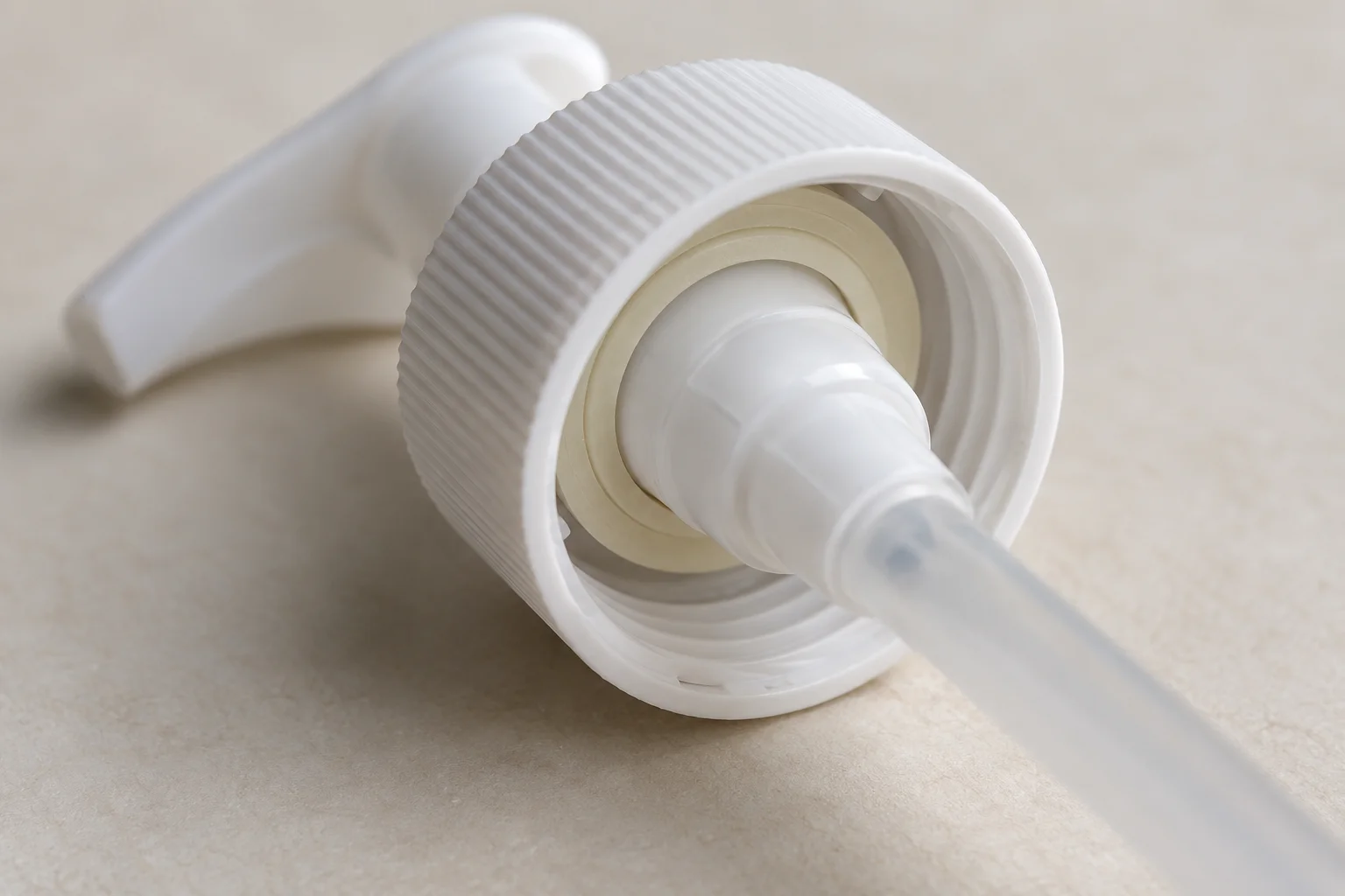 Underside of a white pump collar with a cream-colored annular gasket around its central housing