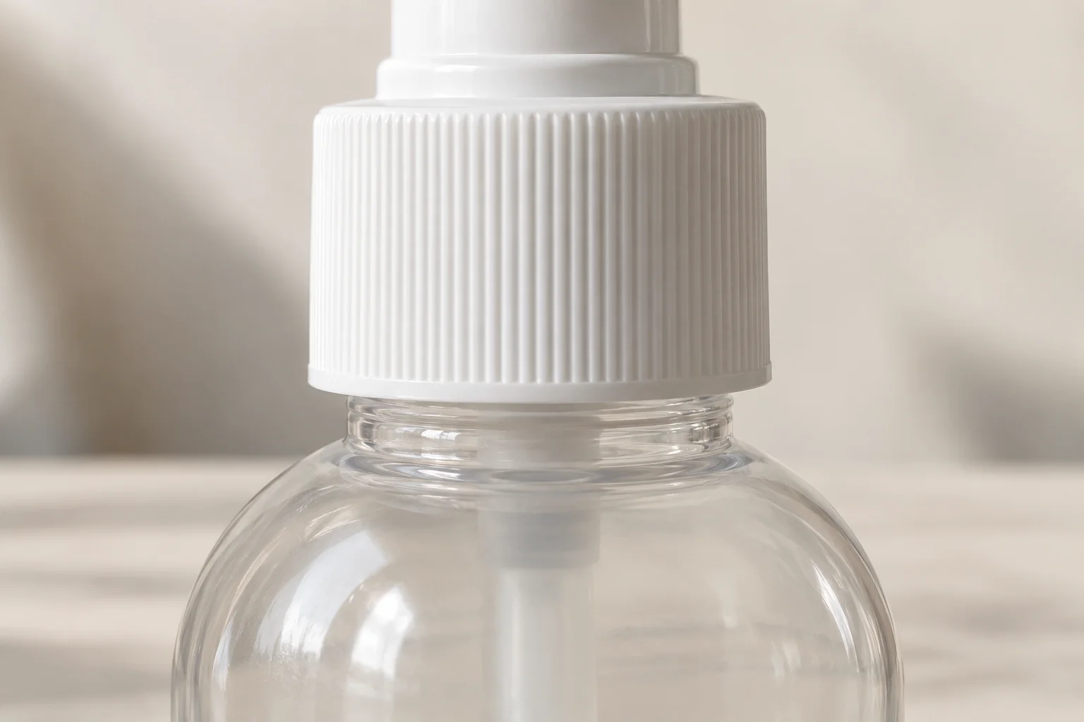 Side view of a white ribbed pump collar with a visible band of clear neck above the bottle shoulder